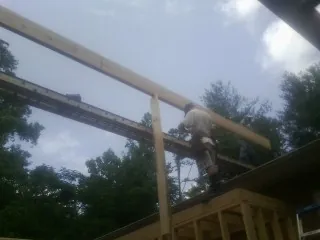 Carpenter setting a ridge beam over a new addition frame — Ice Dam Removal by Roofing Brothers in Garibaldi