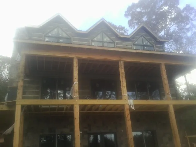 Dormers and porch framing on a large log home under construction — Roof Coating work by our crew in Garibaldi